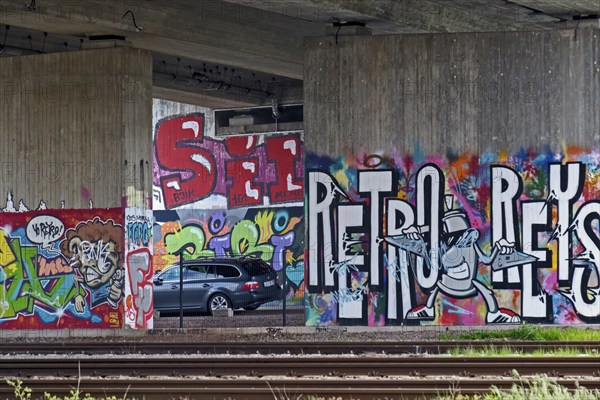 Colourful graffiti on a concrete wall in a subway with parked cars, Rhineland-Palatinate, Germany, Europe