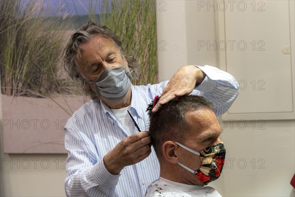 Hairdressing salon in Essen-Rüttenscheid, first customer after 6 weeks, shop closed due to Corona, hairdresser and customer with mouth-nose protection, breathing mask, distance regulation, Essen, North Rhine-Westphalia, Germany, Europe