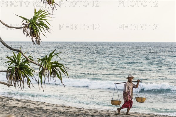 Merchant at Mangsit beach in Sengiggi, seller, man, palm beach, travel, tourism, sea, beach, water, palm tree, ocean, island, coast, tropical, tropics, Asian, natural landscape, untouched, tourism, holiday, lonely, deserted, tranquillity, authentic, authenticity, original, atmosphere, holiday mood, long-distance travel, tradition, traditional, poverty, culture, tradition, holiday idyll, Lombok, Indonesia, Asia