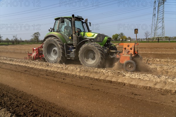 A farmer builds asparagus ridges on a field with the help of an asparagus tiller, in which the asparagus then grows, Dormagen, North Rhine-Westphalia, Germany, Europe