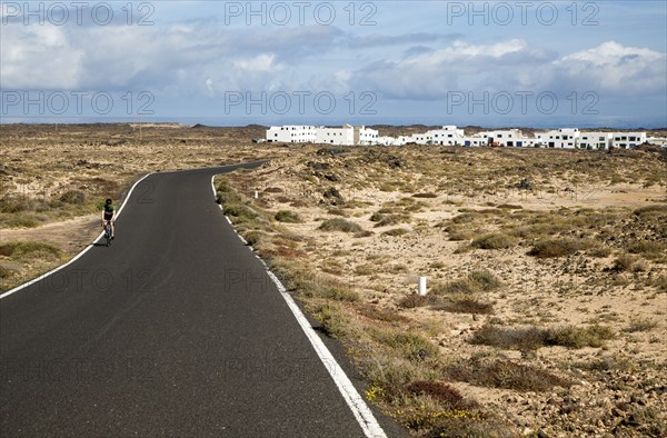 Cyclist on road at Caleta de Caballo village, Lanzarote, Canary islands, Spain, Europe