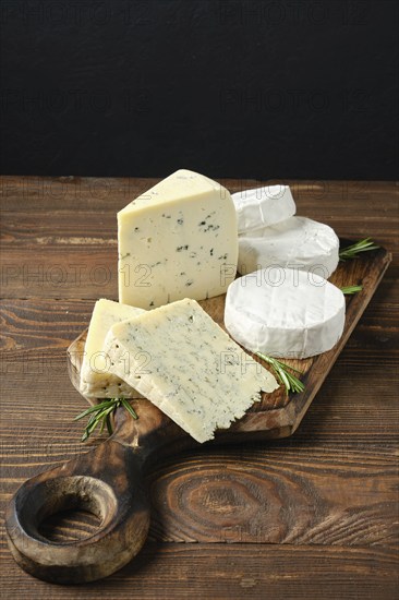 Wooden serving boar with different white cheeses