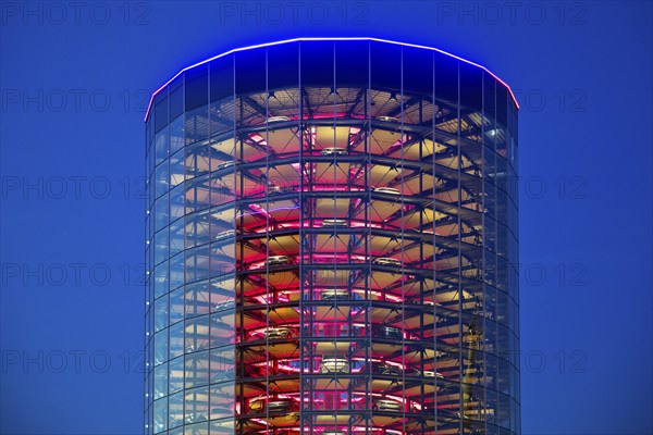 An illuminated car tower with new cars for delivery in the evening, Autostadt, Volkswagen AG, Wolfsburg, Lower Saxony, Germany, Europe