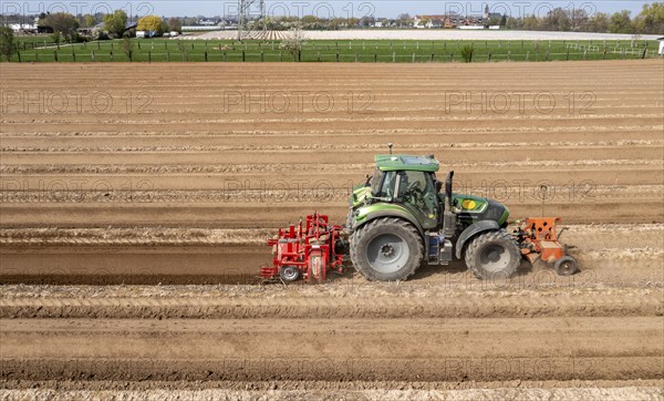 A farmer builds asparagus ridges on a field with the help of an asparagus tiller, in which the asparagus then grows, Dormagen, North Rhine-Westphalia, Germany, Europe