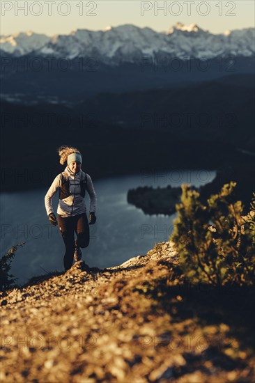 Trail running in autumn on the Jochberg on Lake Walchensee against the wonderful backdrop of the Alps, Bavaria, Germany, Europe