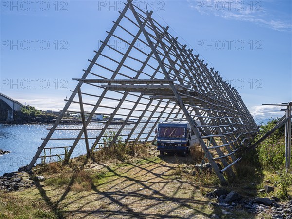 Mobile home, oldtimer, parking below wooden drying rack usually used to dry cod in winter, Henningsvær, Austvagøy, Lofoten, Norway, Europe