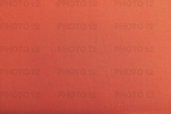 Fragment of smooth red silk tissue. Top view, flat lay, natural textile background and texture