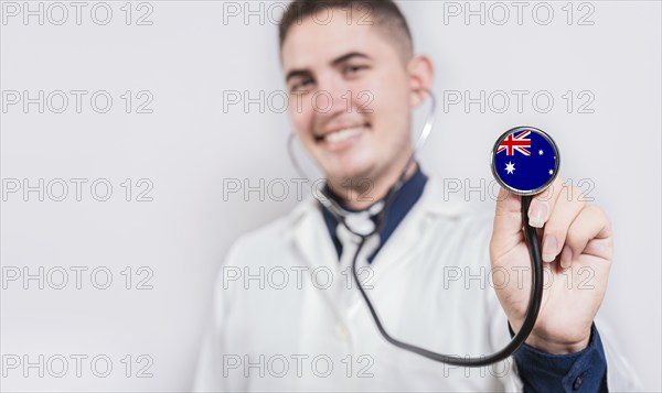 Smiling doctor showing stethoscope with Australia flag. Australia National Healthcare concept