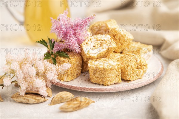 Traditional turkish delight (rahat lokum) with glass of green tea on a gray concrete background and linen textile. side view, selective focus, close up