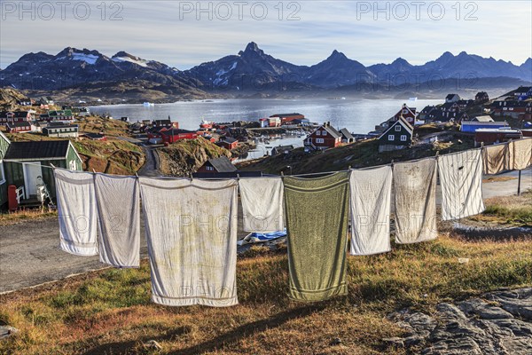 Laundry drying on clothesline in Inuit settlement, houses on a fjord with steep mountains, autumn, Tasiilaq, East Greenland, Greenland, North America