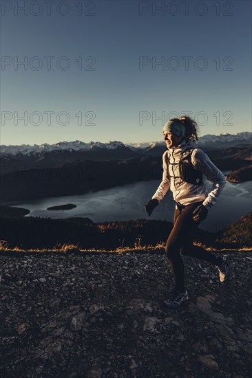 Trail running in autumn on the Jochberg on Lake Walchensee against the wonderful backdrop of the Alps, Bavaria, Germany, Europe