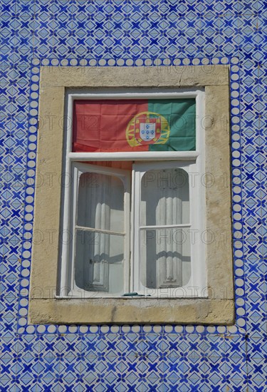 House facade with azulejos wall tiles and the Portuguese flag in the window, historic city district, Alfama, Lisbon, Lisbon District, Portugal, Europe