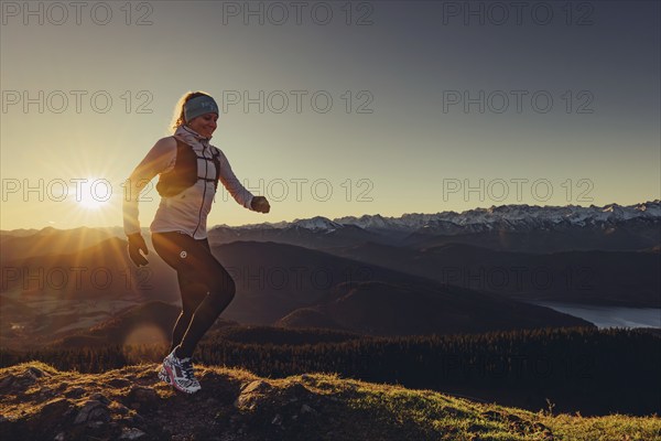 Trail running in autumn on the Jochberg on Lake Walchensee against the wonderful backdrop of the Alps, Bavaria, Germany, Europe