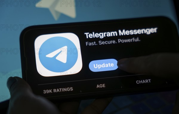 The social media Telegram messenger logo is being displayed on a smartphone screen and on a computer screen