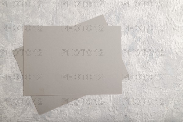 Gray paper business card, mockup on gray concrete background. Blank, flat lay, top view, still life, copy space