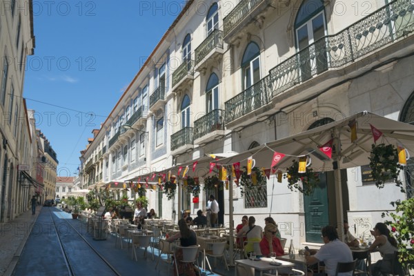 A street café in front of historic buildings in an old town under a blue sky with a relaxed atmosphere and parasols, Rua Nova da Trindade, Old Town, Lisbon, Lisboa, Portugal, Europe