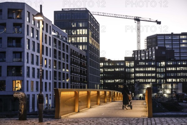 People walk over the Golda Meir footbridge in the Europacity Berlin development area on Heidestrasse. The Europacity project covers an area of 61 hectares. Around 3, 000 flats and office space are being built, 06.01.2022