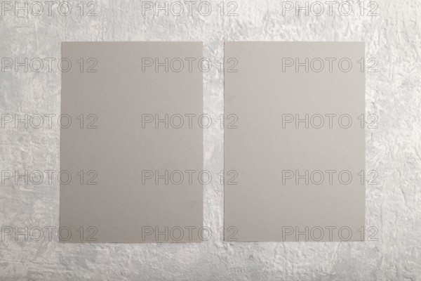 Gray paper business card, mockup on gray concrete background. Blank, flat lay, top view, still life, copy space