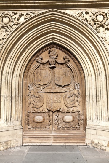 Detail of wooden door and stone arched entrance to the abbey church, Bath, Somerset, England, United Kingdom, Europe