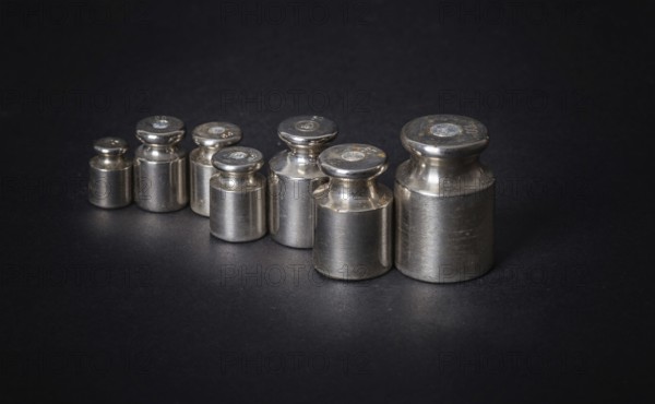 A set of small metal weights on a gray background