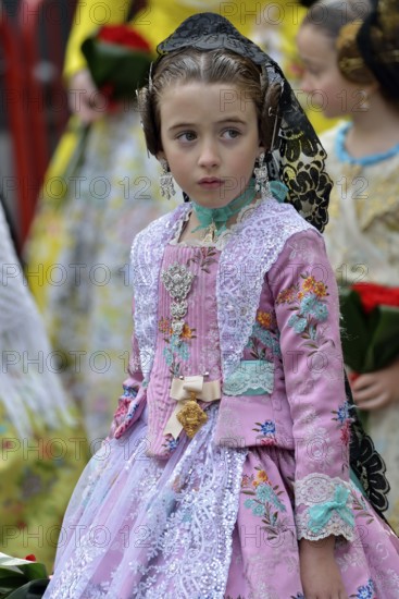 Fallas festival, girl in a traditional costume during the parade in the Plaza de la Virgen de los Desamparados, Valencia, Spain, Europe