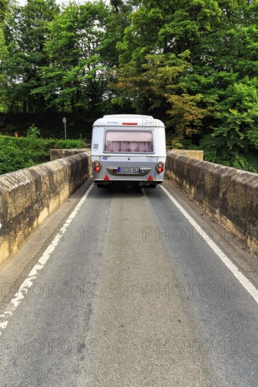 Eriba Touring caravan drives over single lane bridge, River Dee, cult, retro, Llangollen, Wrexham, Wales, Great Britain