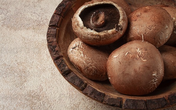 Fresh Portobello mushrooms, in a wooden bowl, top view, close-up, no people