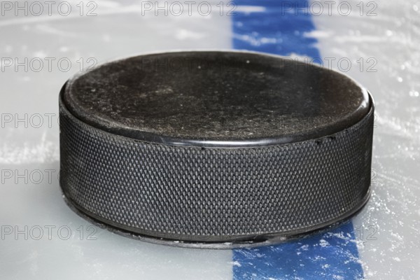 Symbolic image of ice hockey: close-up of a puck on the ice