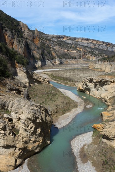 A winding river flows through a rocky gorge in a mountainous landscape under a clear sky, Noguera Ribagorçana Mont-rebei Natural Park, Montsec mountain range, Noguera Ribagorçana river, Lleida province, Catalonia, Aragon, Spain, Europe