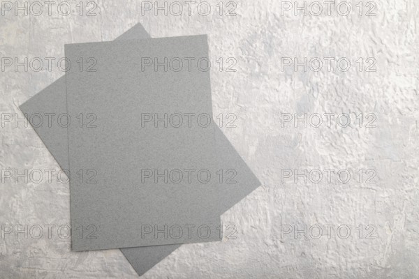 Gray paper business card, mockup on gray concrete background. Blank, flat lay, top view, still life, copy space