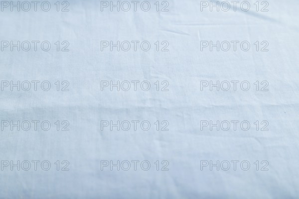 Fragment of smooth cotton blue tissue. Side view, natural textile background and texture