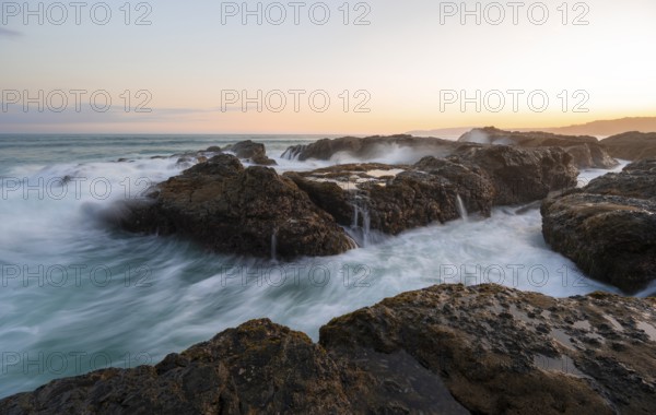 Waves washing over rocks by the sea, long exposure, coastal landscape at sunset, Playa Cocalito, Pacific coast, Nicoya Peninsula, Puntarenas province, Costa Rica, Central America