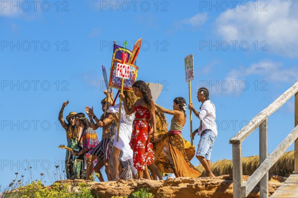 Colourfully dressed youths with musical instruments and banners form a love parade and promote the nightclub Pacha, Cala Comte, Ibiza, Balearic Islands, Mediterranean Sea, Spain, Europe