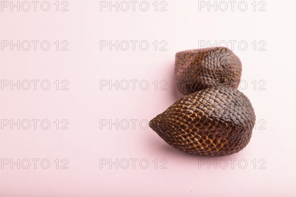 Salak or snake fruit on pink pastel background. Side view, copy space. Tropical, healthy food, summer, exotic, minimalism