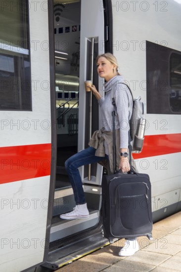 Young woman gets on a train