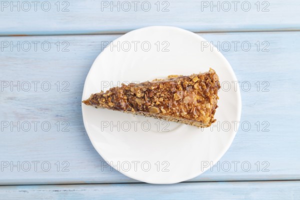 Walnut and hazelnut cake with caramel cream on blue wooden background. top view, flat lay, copy space