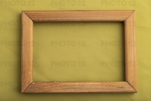 Wooden frame on smooth green olive silk tissue. Top view, flat lay, natural textile background and texture