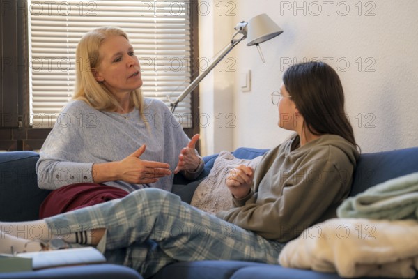 Mother and daughter, teenage, 13 years old, in a confidential conversation, at home