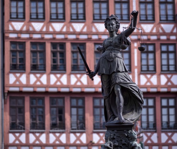 Justitia, Roman goddess of justice, with scales but without blindfold, in front of half-timbered house on Römerberg, Old Town, Frankfurt am Main, Hesse, Germany, Europe