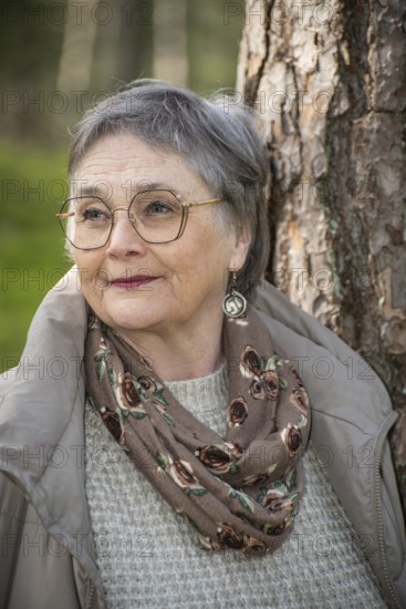 Portrait of elderly woman, 65 years old, enjoying nature in the forest in Ystad, Skåne, Sweden, Scandinavia, Europe