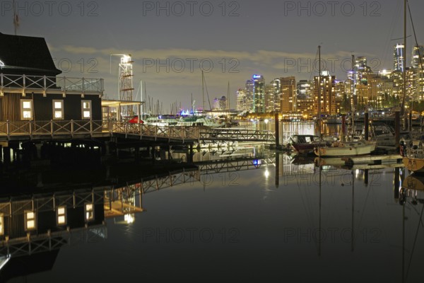 Atmospheric shot of a harbour at night with illuminated buildings and boats, Stanley Park, Vancouver Downtown, British Columbia, Canada, North America