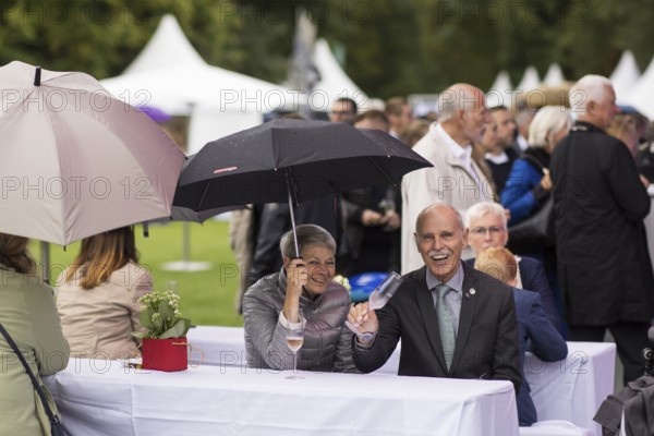 Guests under umbrellas at the Federal President's citizens' festival in Bellevue Palace Gardens, Berlin, 13/09/2024