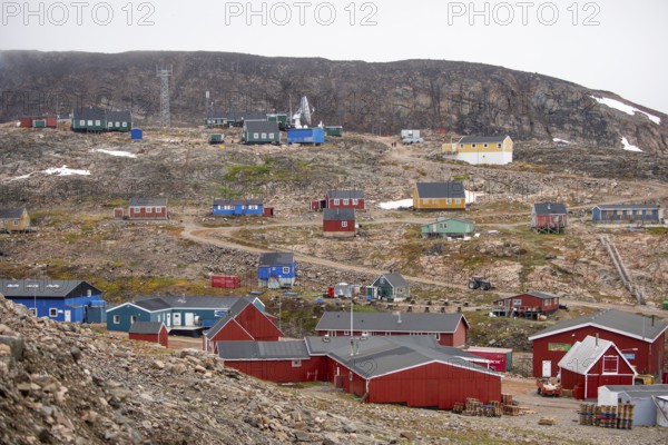 Small, colourful houses are scattered on a rocky slope, secluded Arctic Inuit settlement Ittoqqortoormiit, Scoresbysund or Scoresby Sund or Greenlandic Kangertittivaq, East Greenland, Greenland, North America