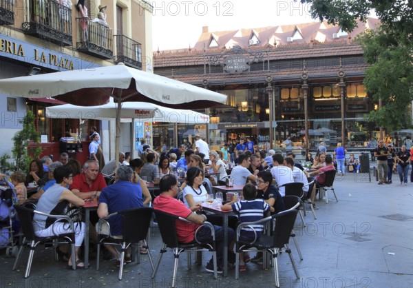 People sitting at street cafe nearby Mercado de San Miguel market, Madrid city centre, Spain, Europe