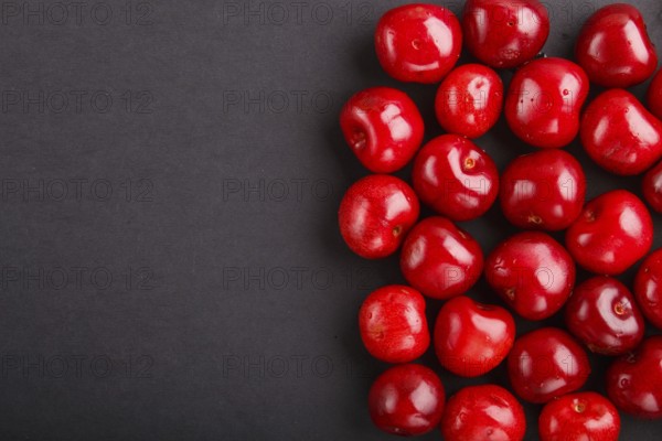 Cherries on black background, top view, flat lay, copy space