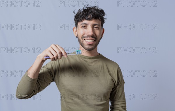 Close up of man holding a dental brush isolated, Handsome man holding dental brush. Tooth brushing and care concept. Smiling guy holding dental brush isolated