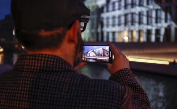 A man takes a photo of the Humboldt Forum with a smartphone during the Festival of Lights, Berlin, 07.10.2024, Berlin, Berlin, Germany, Europe