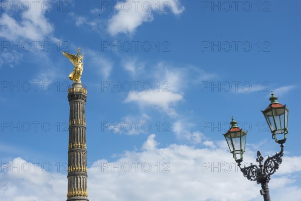 Victory Column next to a beautiful, old street lamp in a blue sky with white clouds, towering column with angel figure, angel, bronze sculpture, bronze, barn swallows (Hirundo rustica) in the sky, Victory Column on the Great Star with gilded, winged goddess of victory Victoria (artist: Friedrich Drake), in Berlin vernacular also Goldelse, national monument, sight, Großer Tiergarten, Berlin Mitte, city of Berlin, Germany, Europe