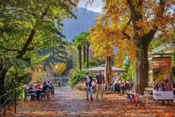 Winter promenade on the River Passer with street café in autumn, Merano, Burggrafenamt, Adige Valley, South Tyrol, Italy, Europe