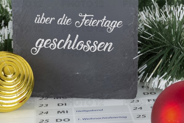 Board with the inscription CLOSED OVER THE HOLIDAYS on a calendar for 2025